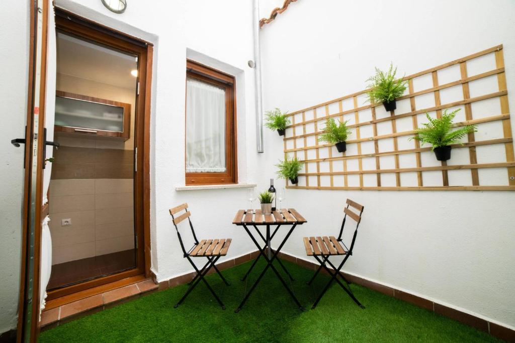 a small table and chairs in a room with grass at casa muralla - plaza mayor in Ciudad-Rodrigo