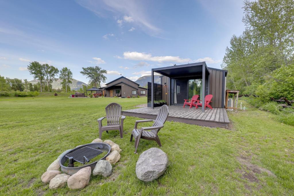 a tiny house with two chairs and a grill at On the Flathead River! Rustic Saloon-Themed Cabin in Columbia Falls