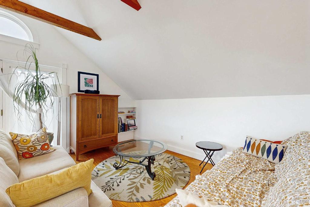 a living room with a couch and a glass table at Charming cottage close to the beach in Truro