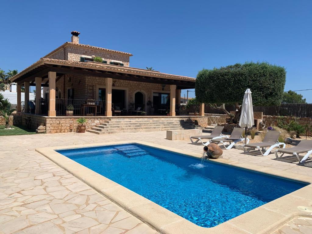 a swimming pool in front of a house at Ca Na Marina in Cala Llombards