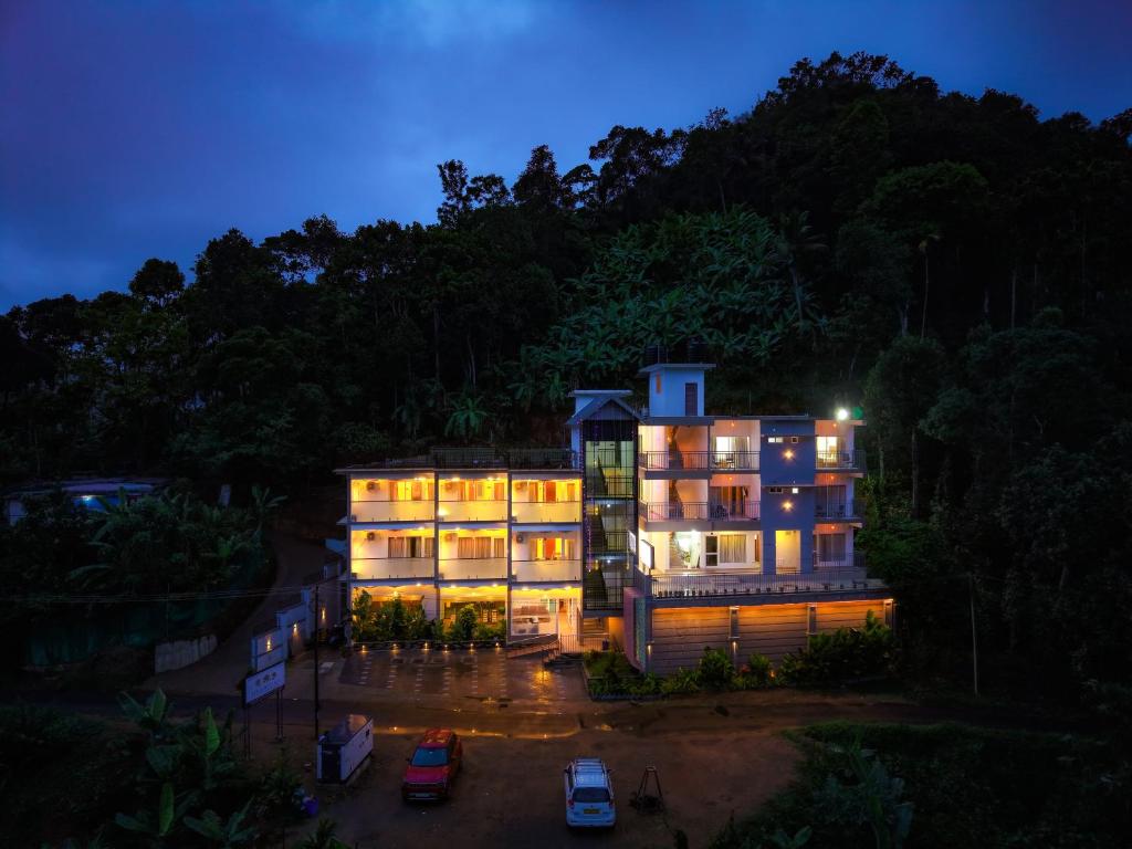 a building at night with cars parked in front at Sky Dale Pool Resort Munnar in Munnar