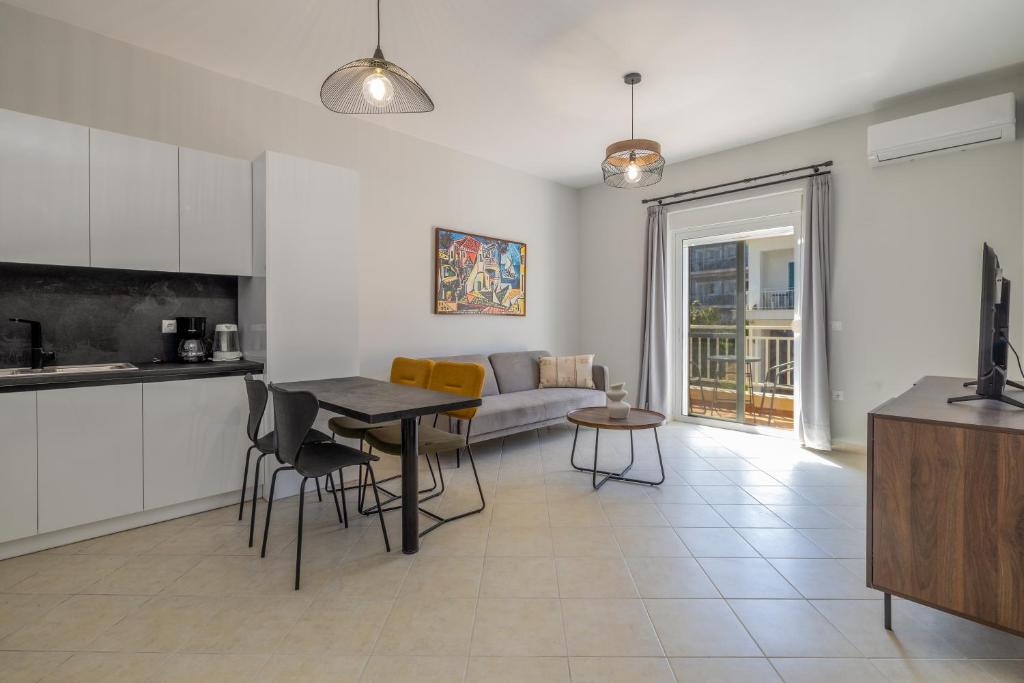 a kitchen and living room with a table and a couch at Blue Skala - Indigo Apartment I in Skala