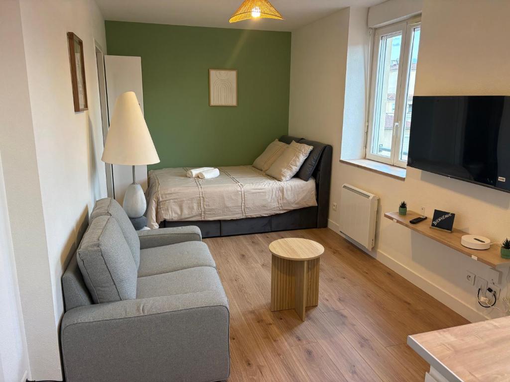 a small living room with a couch and a bed at Cocon de la gare in Montélimar