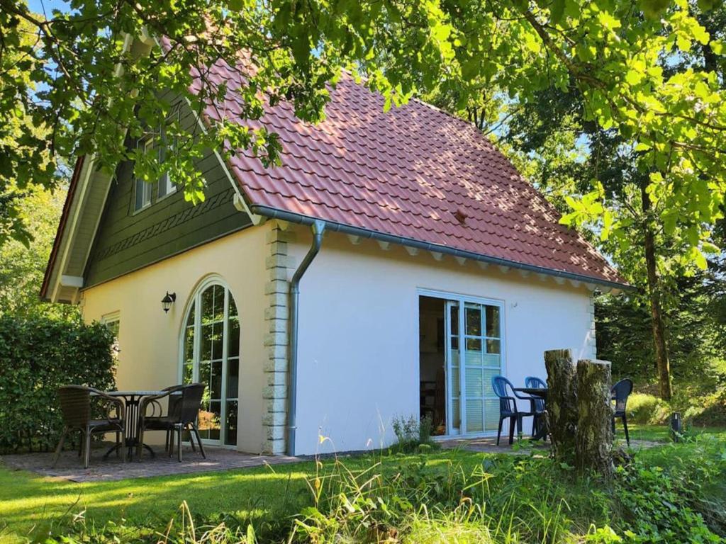 a small white house with a table and chairs at Landhuis Schneifel in Brandscheid