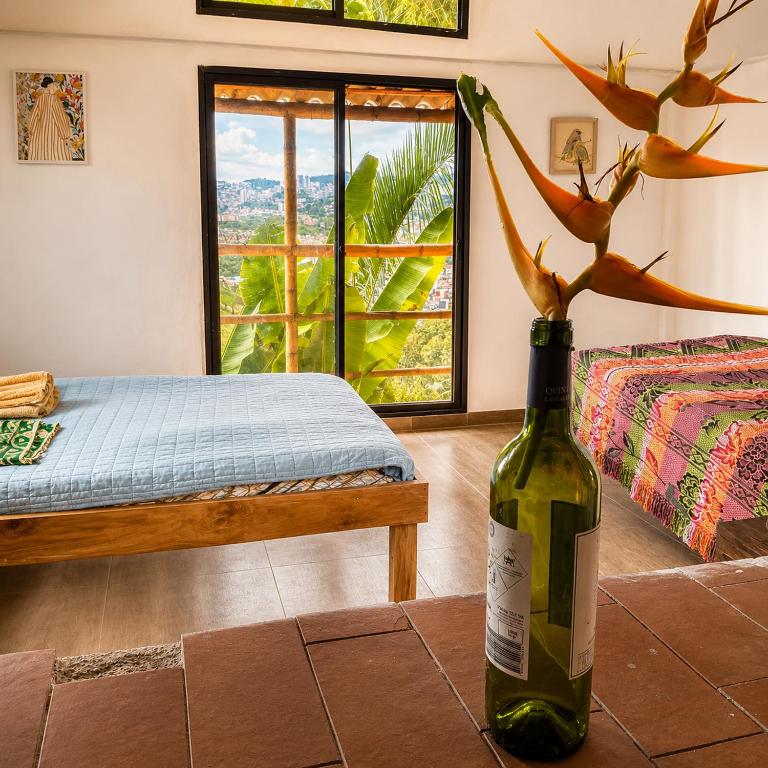 a room with a bottle of wine and a bed at ECOHostal Las Hamacas Rincon Del Árbol in Villamaría