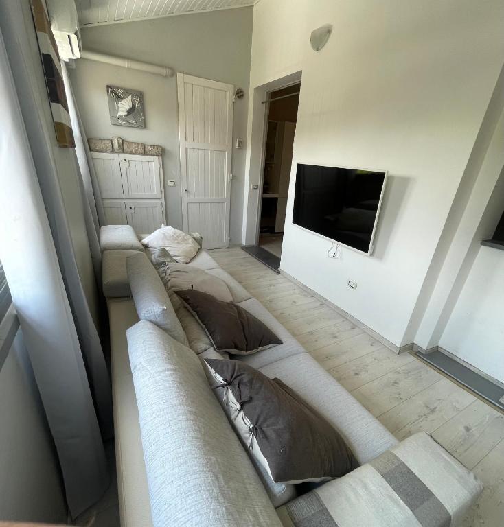 a living room with a long couch and a tv at Casa Estense in Lido degli Estensi