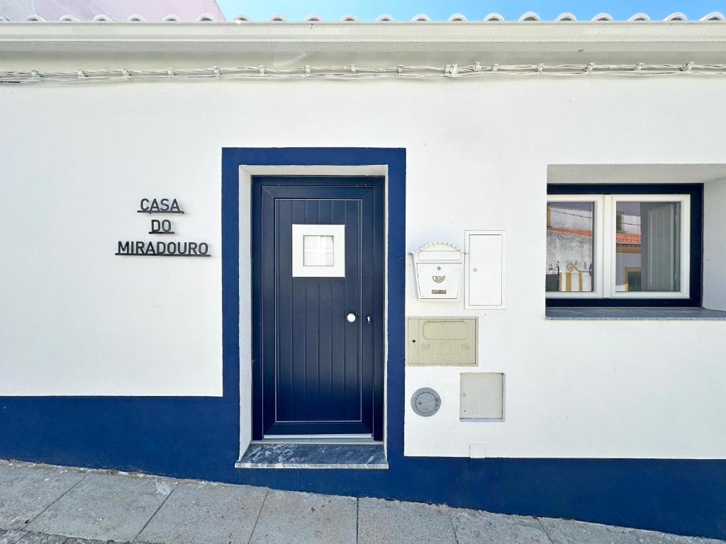 a building with a blue door on the side of it at Casa do Miradouro in São Bartolomeu do Outeiro