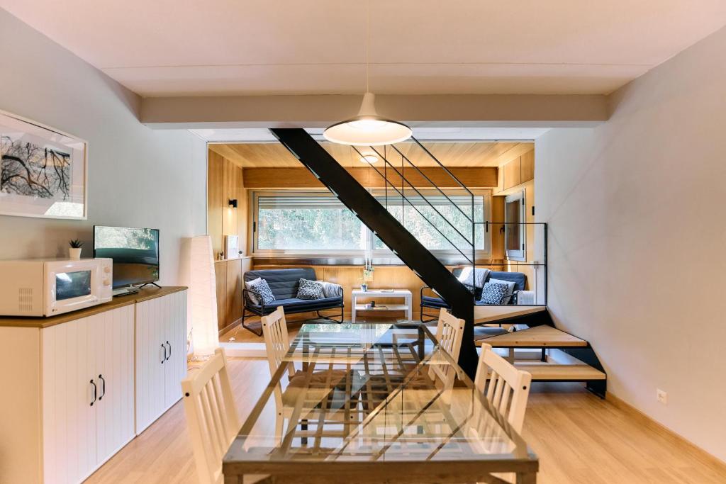 a dining room and living room with a staircase in a house at Apartamento Duplex en La Molina in Alp