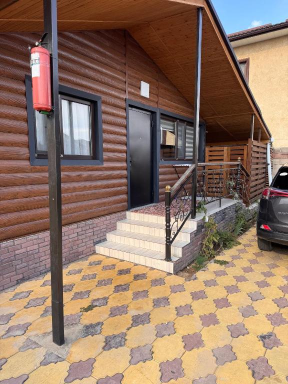 a house with a black door and a car parked outside at Issyk-kul home in Korumdy