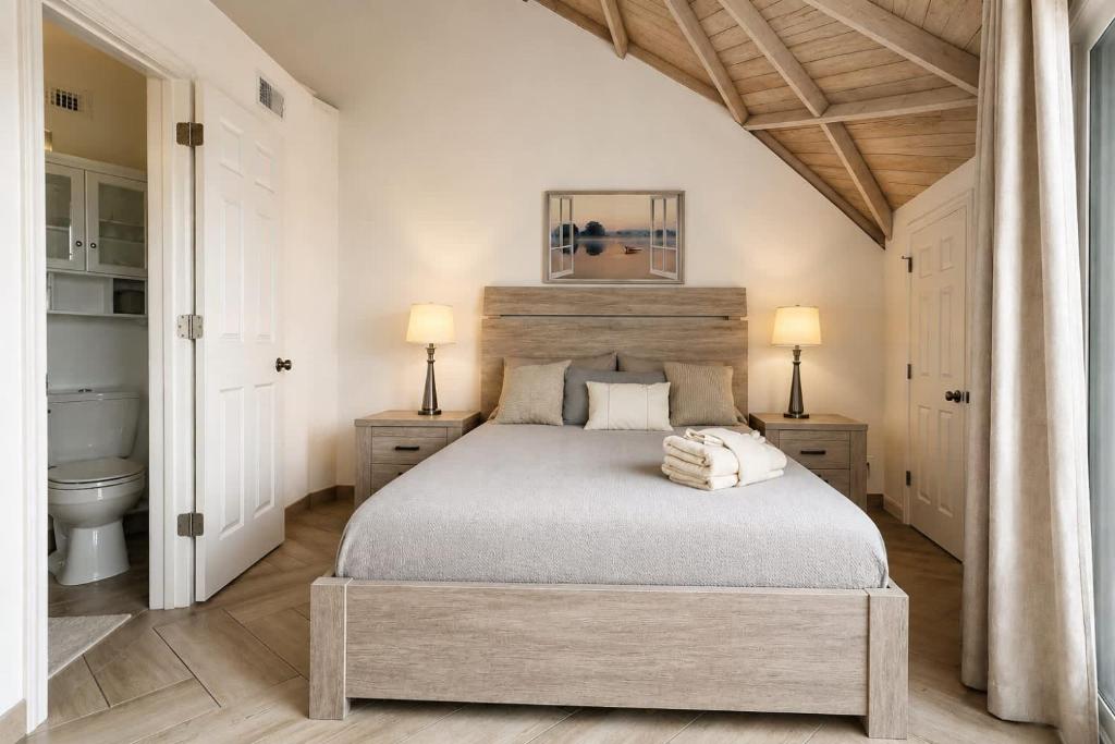 a bedroom with a large bed and two lamps at ROOM 04 - Lake Sumner in Clermont