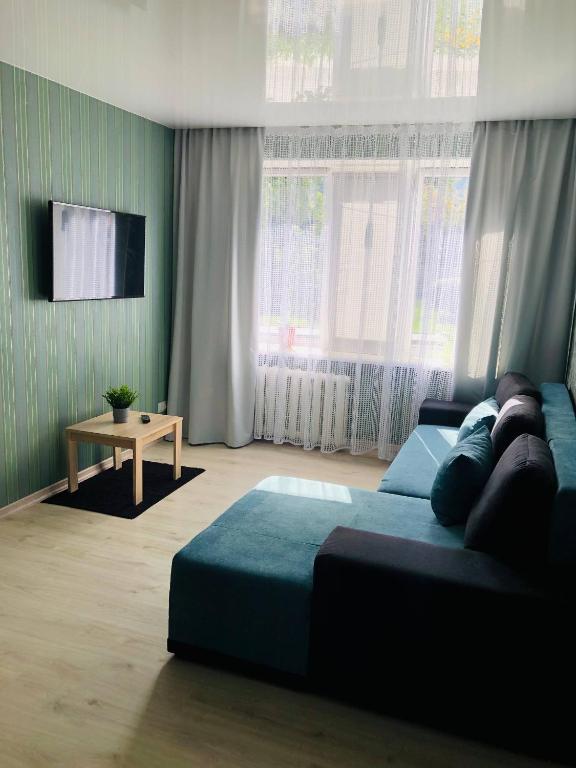 a bedroom with a blue bed and a television at Apartment VV in Volodymyr-Volynskyi