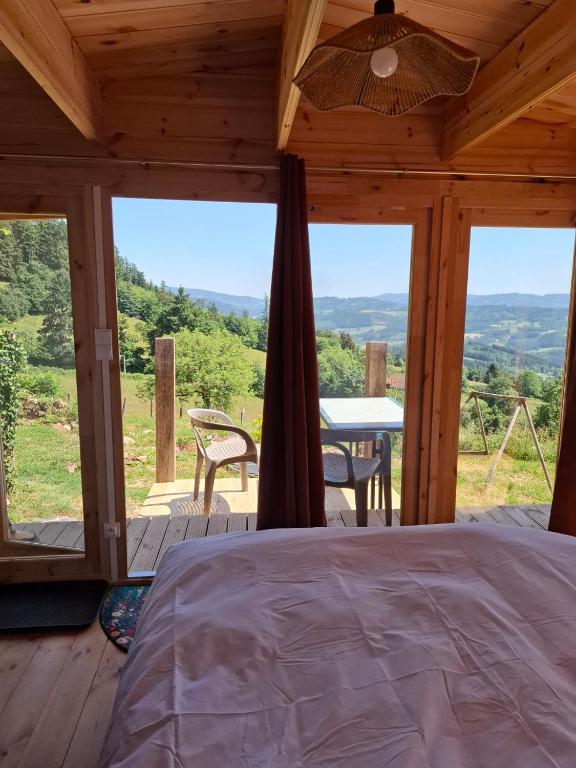 a bedroom with a bed and a table with a view at Cedre bleu in Saint-Racho