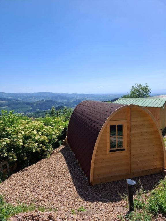 a small circular building with a roof on a hill at Houx POD in Saint-Racho