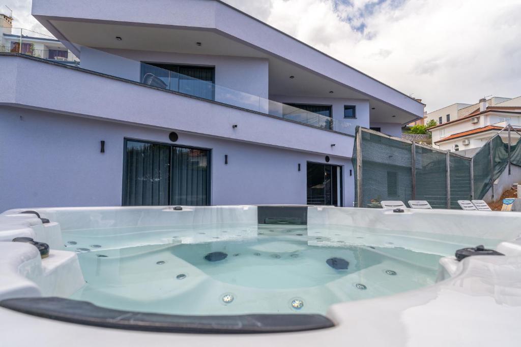 a hot tub on the balcony of a house at Villa Viola in Lovran