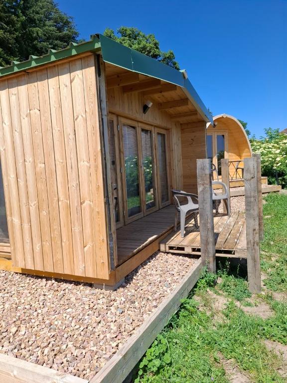 a wooden cabin with a deck and a bench at Douglas in Saint-Racho