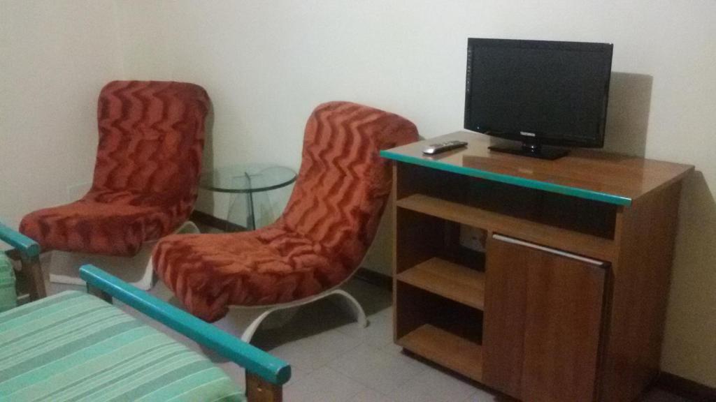 a living room with two chairs and a television at Hotel Fiera in Pesaro
