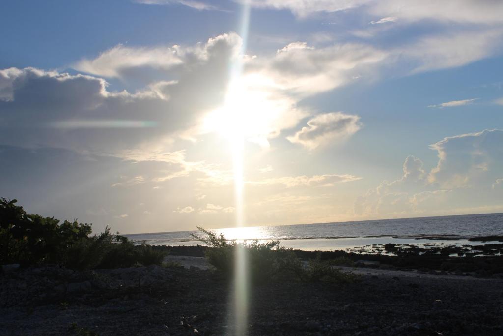 Sonnenuntergang über dem Meer an einem Strand in der Unterkunft Faatiarau in Fakarava