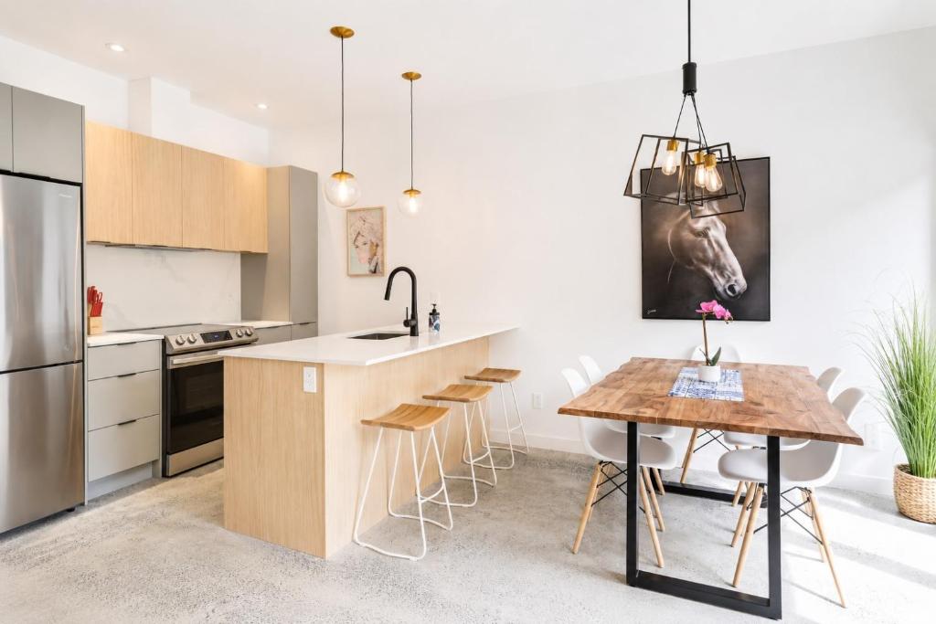 a kitchen with a wooden table and a counter top at Amazing 2BR condo with private terrace presented by TripMontreal II in Montreal