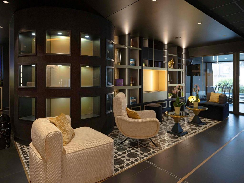 a large living room with two chairs and a couch at Mercure Orléans Centre Bords de Loire in Orléans