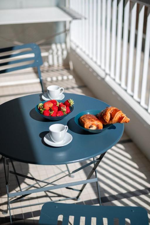 a blue table with two plates of food and croissants at LE PALAIS Centre-Ville - Proche Mer Terrasse Wifi in Menton