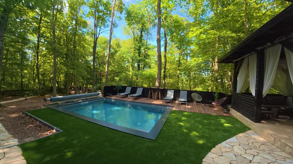 a swimming pool in the middle of a yard at Forest Escape with Jacuzzi & Pool Among the Trees by Destination GREEN Croatia in Ivanec