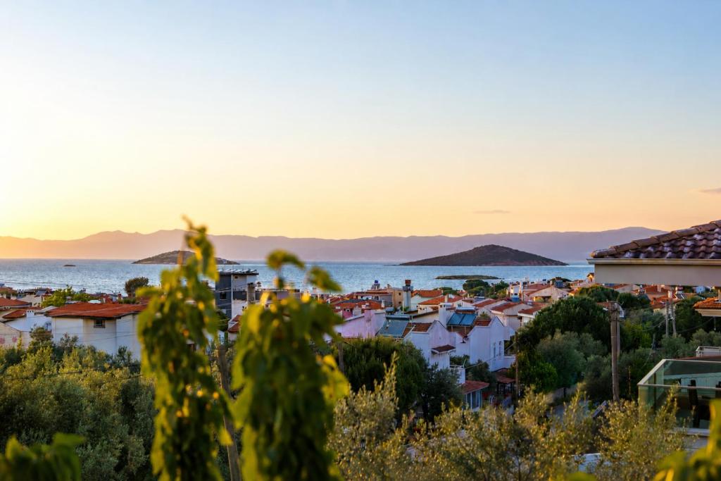 a view of a city and the ocean at sunset at Kent Pansiyon Ayvalık in Ayvalık