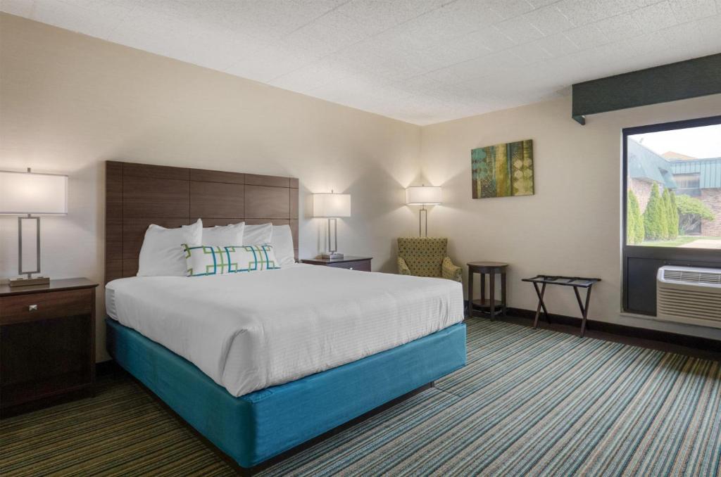 a hotel room with a large bed and a window at Best Western Woodhaven Inn in Woodhaven