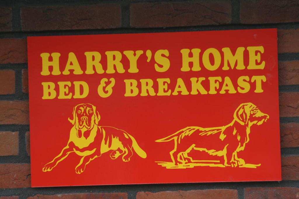 un panneau sur un mur de briques qui lit le harrys home bed and breakfast dans l'établissement Harry's Home Tiel Bed & Breakfast, à Norwich