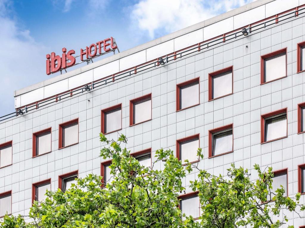 a white building with a sign on top of it at ibis Berlin Messe in Berlin