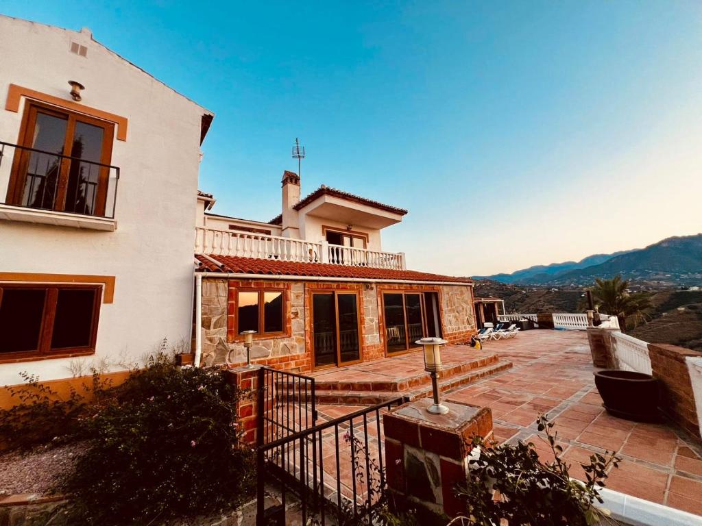 a house with a balcony and a patio at Natura Escapade in Torrox