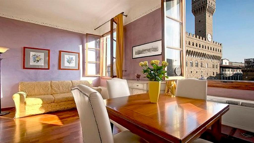 a dining room with a table and a couch at Magic Signoria Apartment in Florence