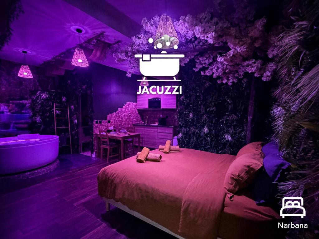 a room with a bed and a bath tub with purple lighting at JUNGLE SUITE - Jacuzzi - Centre - Clim by Narbana in Narbonne