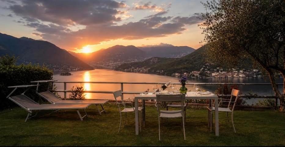 a table and chairs with the sunset in the background at Lake View 30 in Sulzano