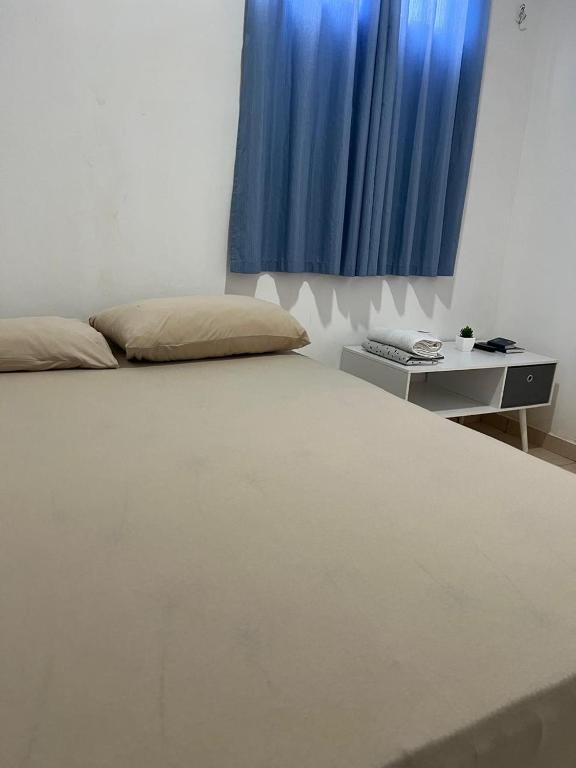 a bedroom with a bed with a blue curtain at Quarto Selva in Itaquatiara