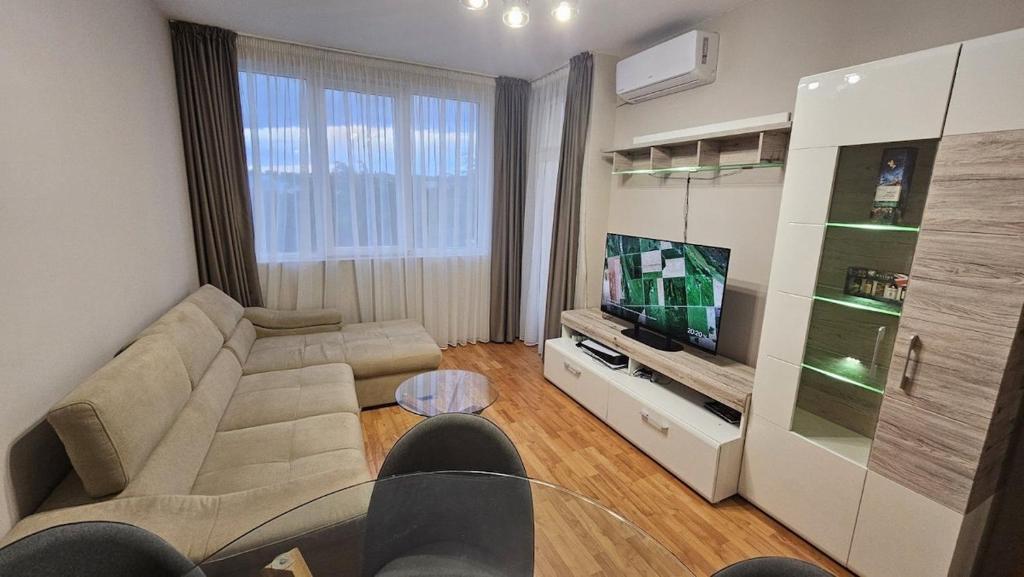 a living room with a couch and a television at Elena Relax Apartment in Varna City