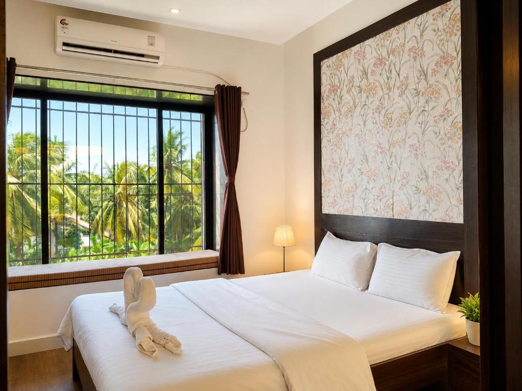 a bedroom with a bed with a stuffed animal on it at The Alibag Beach hotel- Grantley in Alībāg
