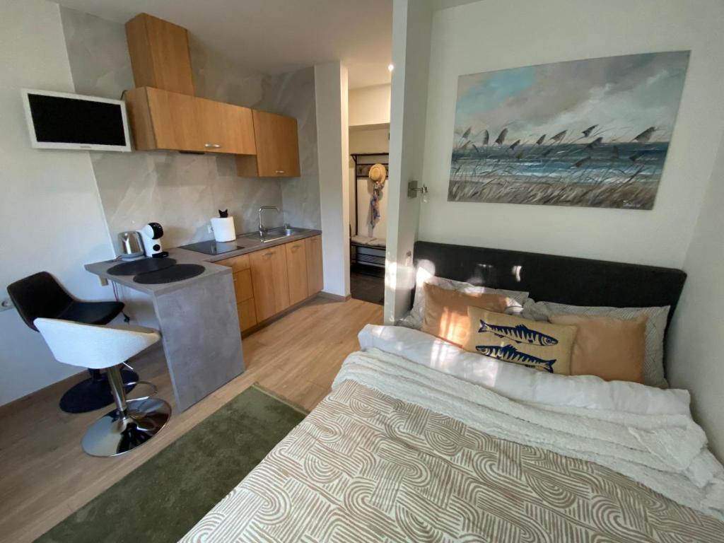 a bedroom with a large bed and a kitchen at Acapulco Liepaja in Liepāja