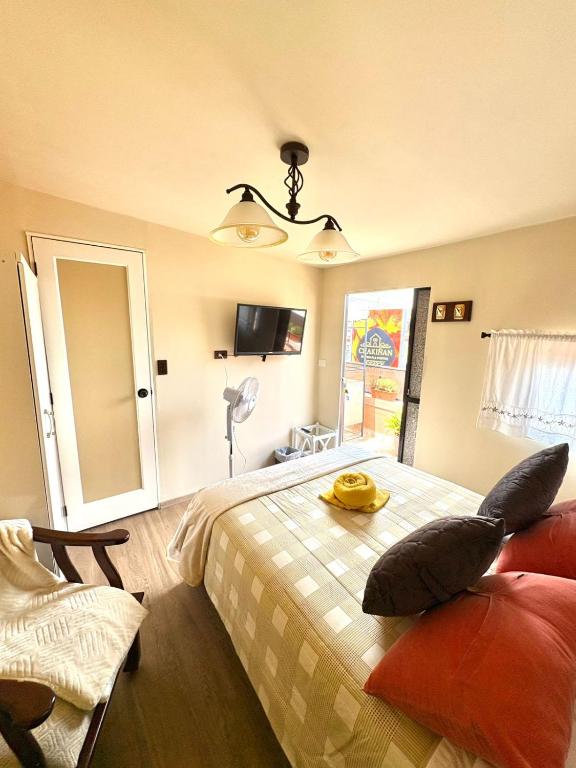 a bedroom with a bed and a chair and a mirror at Chakiñan Hospedaje & Eventos - Tumbaco in Tumbaco