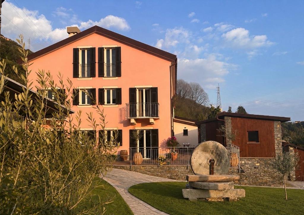 a large pink house with a fountain in front of it at Agriturismo Terra Madre in Rapallo
