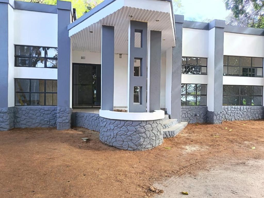 a large building with a stone foundation in front of it at Hazyview Country Cottages in Hazyview
