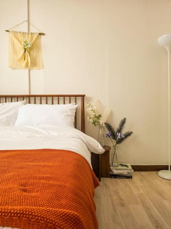 a bedroom with a bed with an orange blanket at Jian Stay Bora in Sin'gal