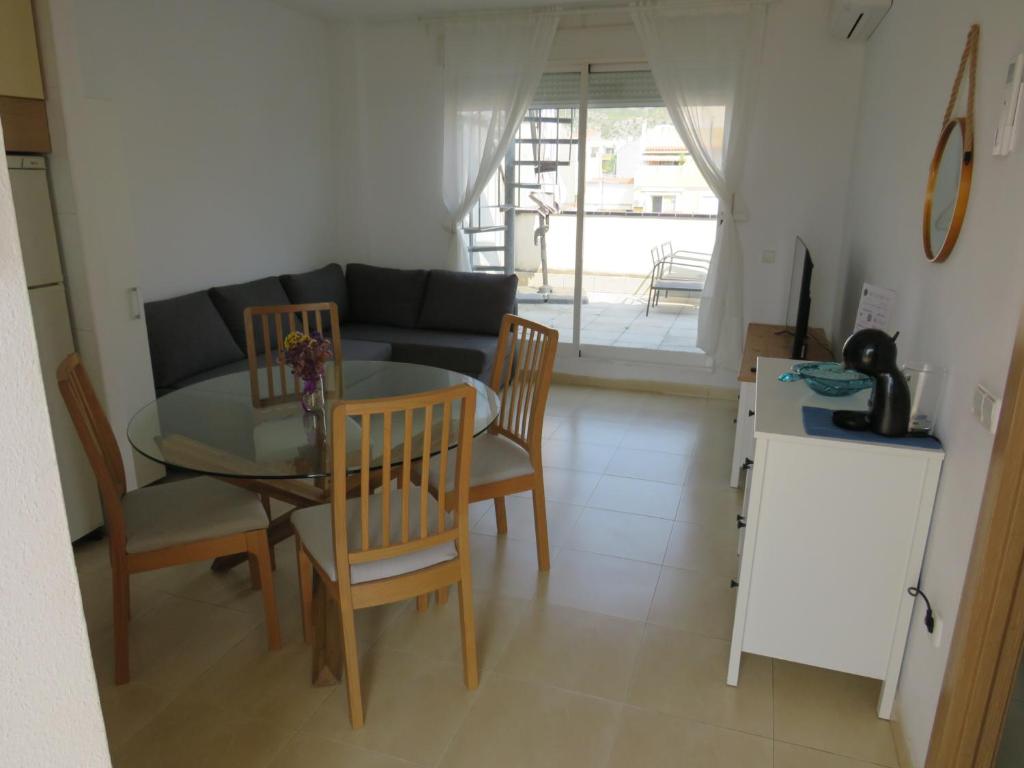 a living room with a table and chairs and a couch at Apartamento Tres Ce in Alcossebre