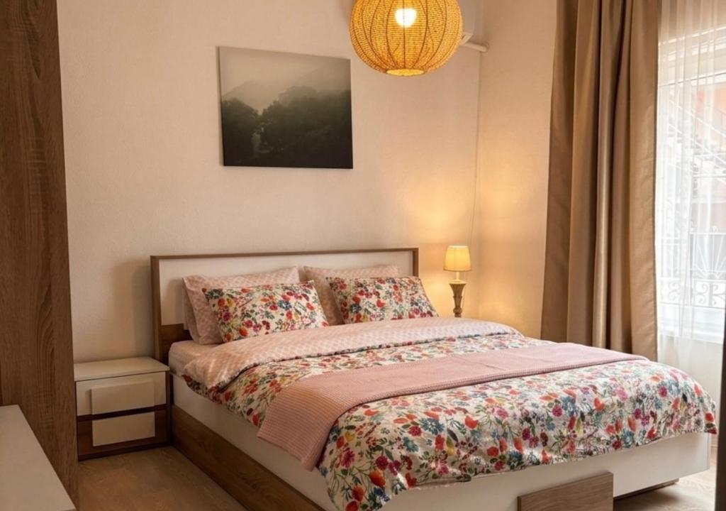 a bedroom with a bed with a flowery bedspread at The Old Corner House in Velingrad