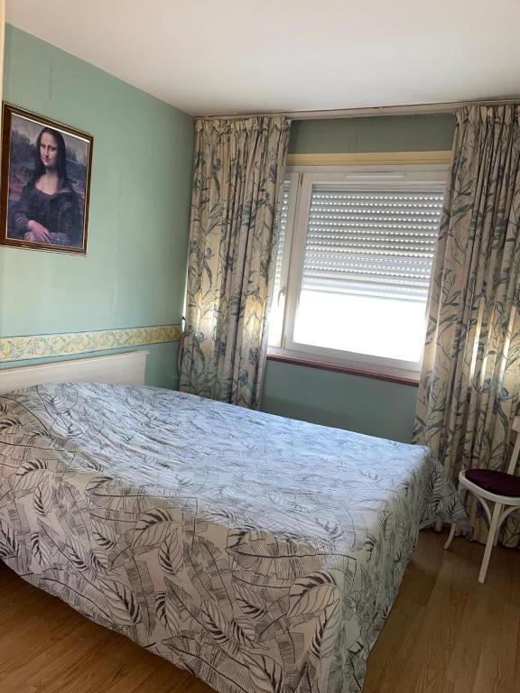 a bedroom with a bed and a window at Appartement Mona Lisa in Ris-Orangis