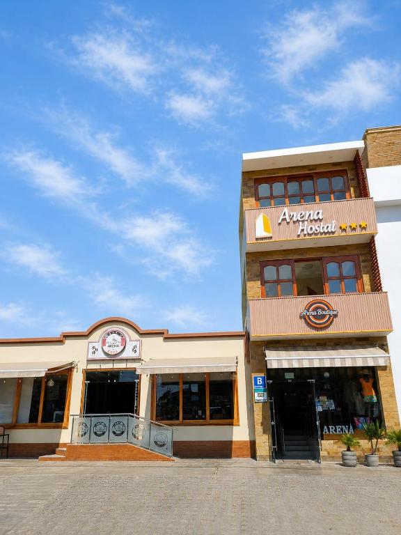 a store front of a building with a sign on it at Arena Hostal in Paracas
