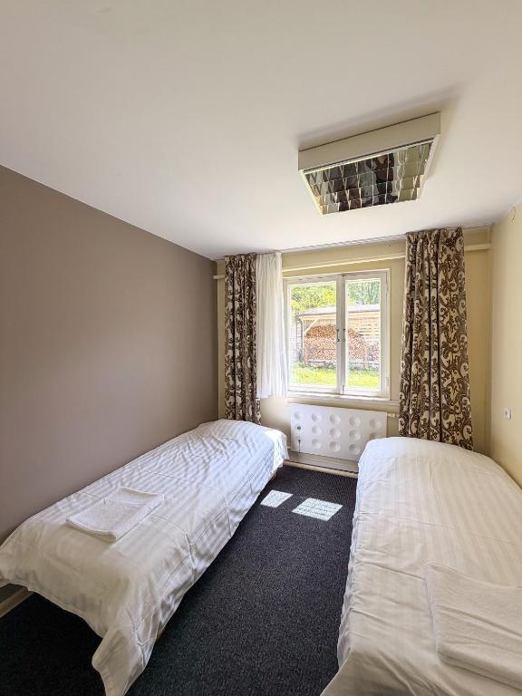 two beds in a bedroom with a window at Sadama Hostel & Caravan Camping in Pärnu