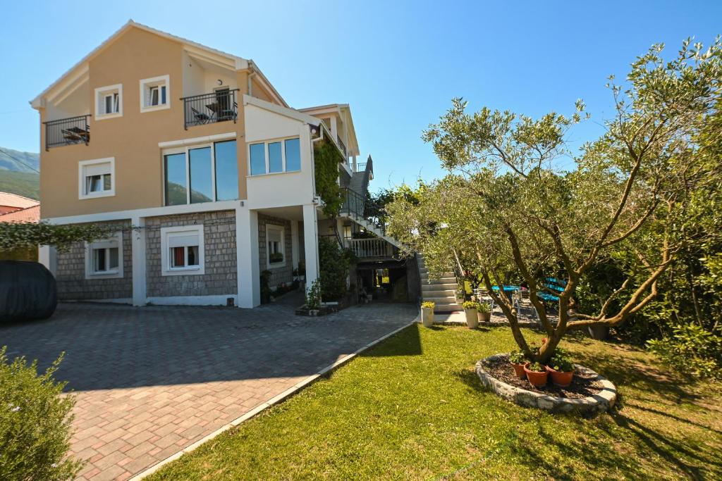a house with a tree in the yard at Green Oasis Residence in Radanovići