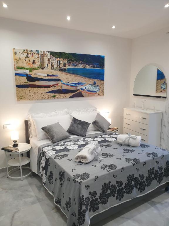 a bedroom with a bed and a painting on the wall at L'Approdo di Re Ruggero in Cefalù
