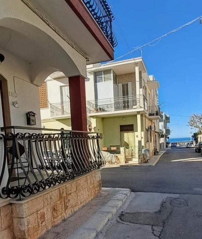 a building with a balcony on the side of a street at Dimora Egnazia in Savelletri di Fasano