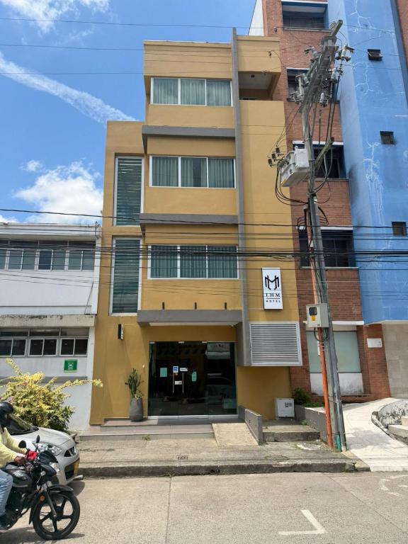 a building with a motorcycle parked in front of it at Hotel LHM in Montería